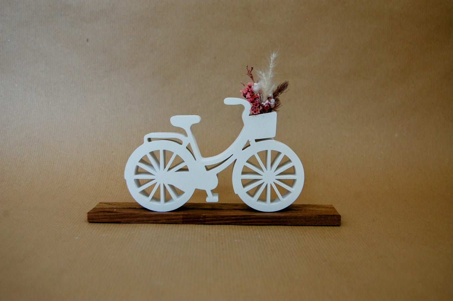 Fahrrad aus Gips mit Holzfuß und Trockenblumen